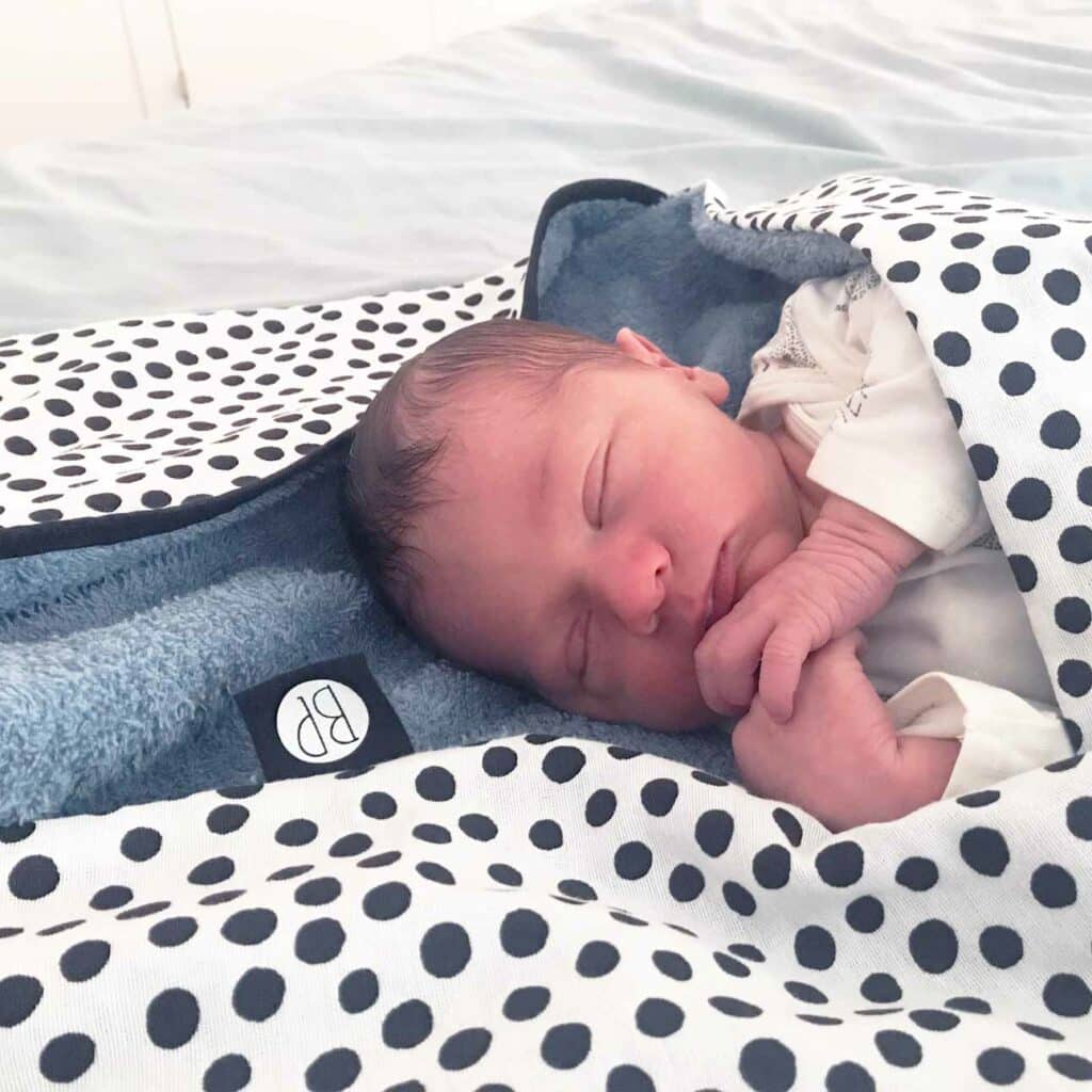 slapende baby in een wikkeldeken Wikkeldoek voor een baby blauw