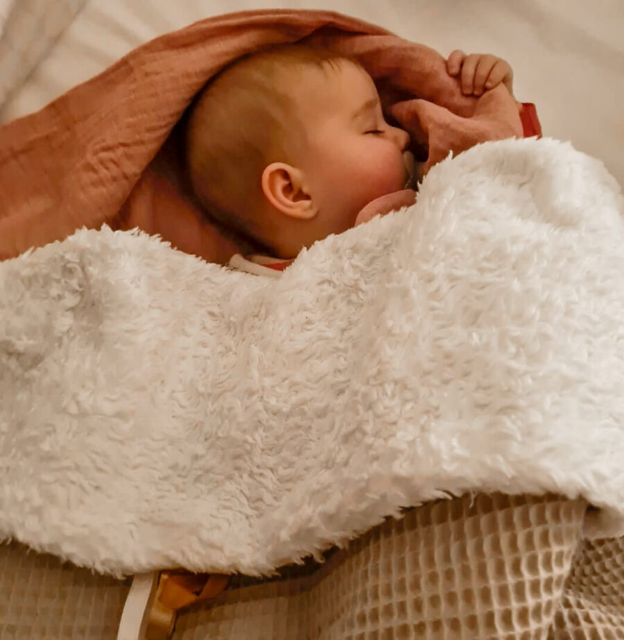 slapende baby onder teddy dekentje wafel zand