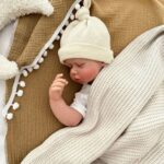 baby slapend met een gebreid dekentje en liggend op een badcape hydrofiel