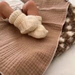 aankleedkussen met een hydrofiele doek erover heen, baby liggend op aankleedkussen